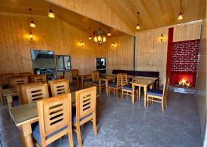 a restaurant with tables and chairs and a fireplace at The host in Kanatal +5 photos