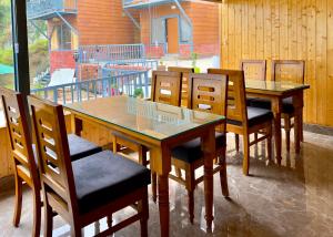a dining room with wooden tables and chairs at The host in Kanatal