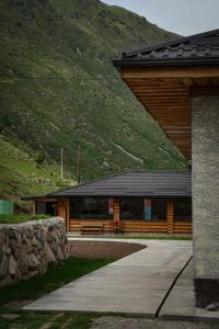 a log cabin with a mountain in the background at RAHMAT yurts in Bishkek
