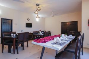 a dining room with a table with pink roses on it at Hotel One Bahawalpur in Bahawalpur