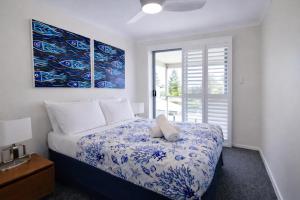 a bedroom with a bed with a blue and white blanket at Scarborough Beach Front Resort - Shell Seven in Perth +43 photos