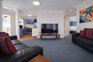 a living room with a couch and a flat screen tv at Scarborough Beach Front Resort - Shell Seven in Perth