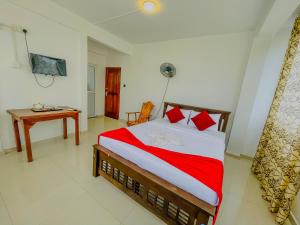 a bedroom with a bed and a desk and a television at Grand View Hotel Kandy in Kundasale