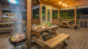 a porch with a grill and a table with food at Goseong Gamnamu Pension in Goseong