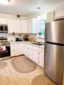 a kitchen with white cabinets and a stainless steel refrigerator at Big Bass Bungalow - Quitman Tx in Quitman +18 photos