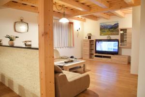 ein Wohnzimmer mit einem Sofa und einem TV in der Unterkunft Sonnenchalet 2 im Salzburger Lungau in Mariapfarr