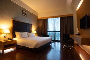 a hotel room with a bed and a large window at Symphony Suites Hotel in Ipoh