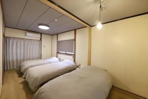 a room with three beds in it at CLIP INN by RITO 坂の上の一棟貸し in Tsushima