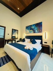 a bedroom with a large bed with a blue blanket at O2 Resort Welimada in Nugatalawa