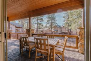 a porch with a wooden table and chairs on a balcony at McB's Mountain Retreat in Flagstaff
