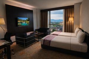 a hotel room with a bed and a large window at Symphony Suites Hotel in Ipoh