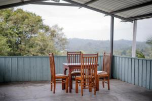 three chairs and a table on a porch at Grand View Hotel Kandy in Kundasale