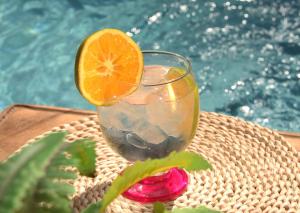 a drink with an orange slice on a table next to a pool at Hotel Rodadero Beach Blue in Santa Marta