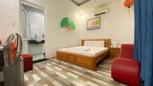 a bedroom with a bed and two red chairs at Nhật Minh Hotel in Thuan An