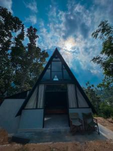 a small house with two chairs in front of it at Alpine Heights in Kumburuteniwela