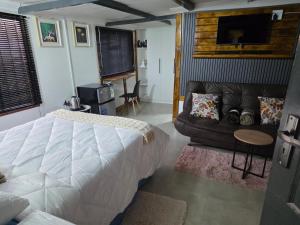 a bedroom with a bed and a couch at CLP Lodge in Bela-Bela