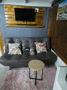 a living room with a black leather couch and a table at CLP Lodge in Bela-Bela