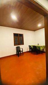 a room with chairs and a table and a window at Mangala gust house in Habaraduwa Central