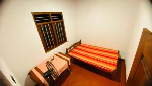 a small room with a bed and a window at Mangala gust house in Habaraduwa Central