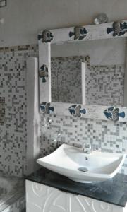 W łazience znajduje się biała umywalka i lustro. w obiekcie Casa Zia Mariolina w mieście Cabras