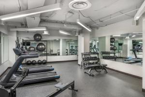a gym with several treadmills and machines in it at The Quincy, an Ascend Collection Hotel in Washington, D.C.