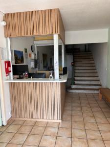 a lobby with a counter and a staircase in a building at Hotel Du Rocher in Le Caylar