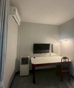 a room with a desk with a monitor and a chair at Butterfly Home Mai Khao Phuket in Ban Suan Maphrao
