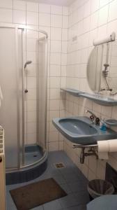 bagno con doccia, lavandino e specchio di Hotel SINOS a Klagenfurt