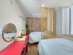 a bedroom with two beds and a mirror and a red counter at Quantum Hotel, Seoul Station br in Seoul