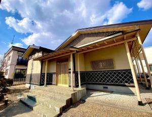 a house with a porch and stairs in front of it at Luxury Villa N and N in Aomori