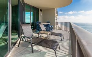 a balcony with chairs and a table and the ocean at Phoenix West 2203 in Orange Beach