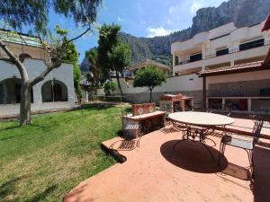 a patio with a table and chairs and a building at Addaura Paradise House in Palermo
