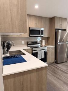 a kitchen with wooden cabinets and stainless steel appliances at Cozy and comfortable in Calgary
