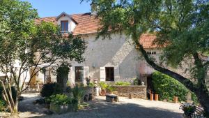 a stone house with trees in front of it at La Vallée Verte in Grandchamp