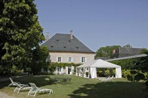 ein großes weißes Haus mit Stühlen und einem Pavillon in der Unterkunft Hostellerie de la Commanderie in Condat-sur-Vézère