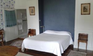 een slaapkamer met een wit bed en een blauwe muur bij Hostellerie de la Commanderie in Condat-sur-Vézère