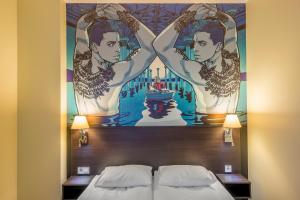 a mural above a bed in a hotel room at Comfort Hotel LT - Rock 'n' Roll Vilnius in Vilnius