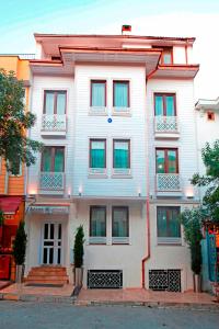 - un bâtiment blanc avec des fenêtres donnant sur une rue de la ville dans l'établissement Azade Suites, à Istanbul