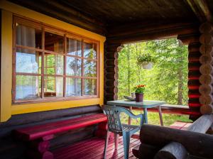 a porch of a cabin with a bench and a table at Eetuntupa in Keuruu