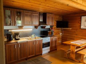 a kitchen with wooden cabinets and a stove top oven at Eetuntupa in Keuruu