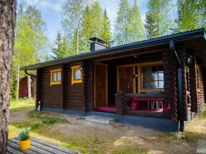 a small log cabin with a porch in the woods at Eetuntupa in Keuruu