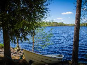 a boat sitting on the shore of a lake at Eetuntupa in Keuruu +3 photos