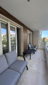 ein Wohnzimmer mit Sofas, Tischen und Fenstern in der Unterkunft Petrus in Rafailovici