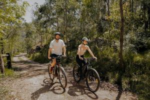 two people riding bikes on a dirt trail at The Lantern - a Huch experience in Wollombi