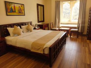 a bedroom with a large bed and a window at The Byke - The Sanctuary Heritage - Pan India Pure Veg Hotel Chain in Kumbhalgarh