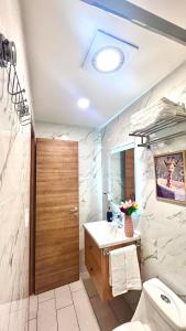 a bathroom with a sink and a toilet and a mirror at Apartamento con vistas, balcón, gym y parking in Tegucigalpa +44 photos