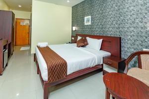 a bedroom with a bed and a chair at Hotel Lals Residency, Adoor in Adūr +25 photos
