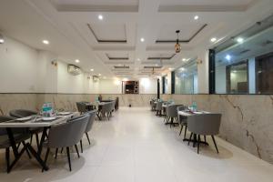a restaurant with tables and chairs in a room at Hotel Krone Plaza Near IGI Airport Delhi in Champawat