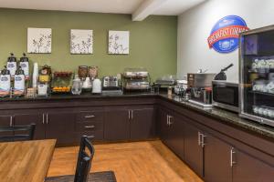 a kitchen with a counter with a microwave and a coffee shop at Baymont by Wyndham Pueblo in Pueblo