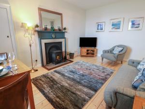 a living room with a couch and a fireplace at North Segganwell - Culzean Castle in Maybole